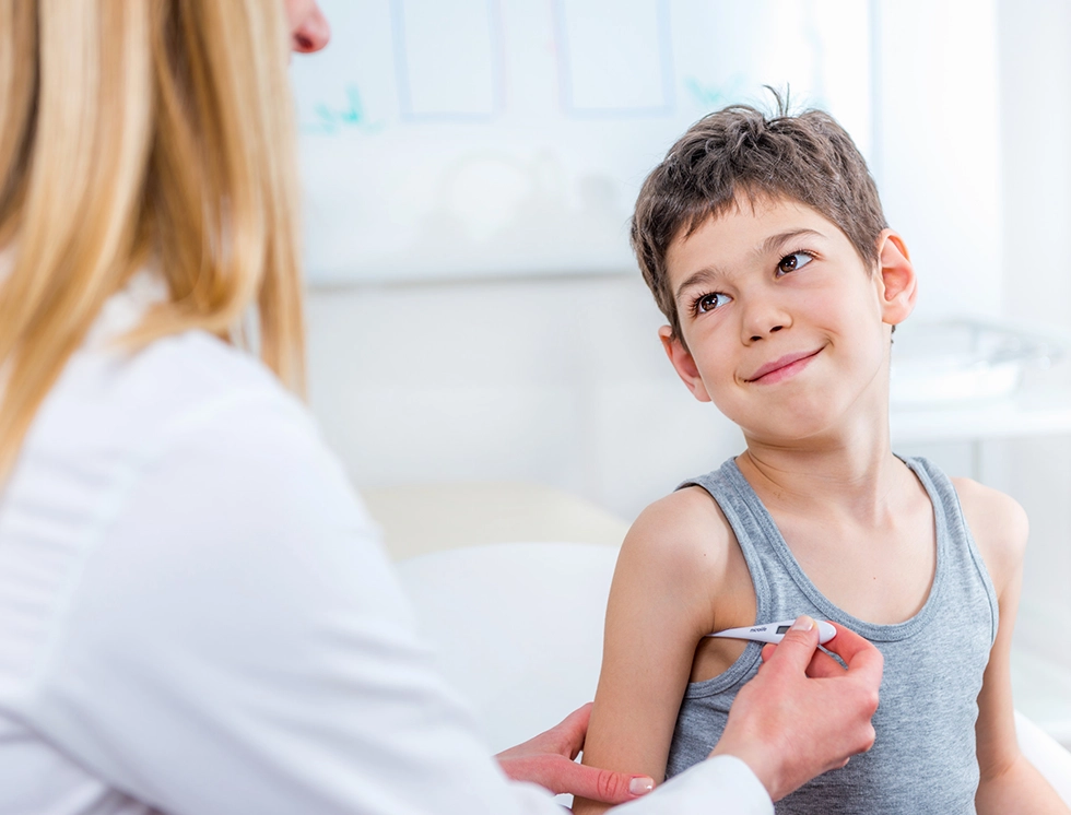 Pediatrician measuring temperature of a boy